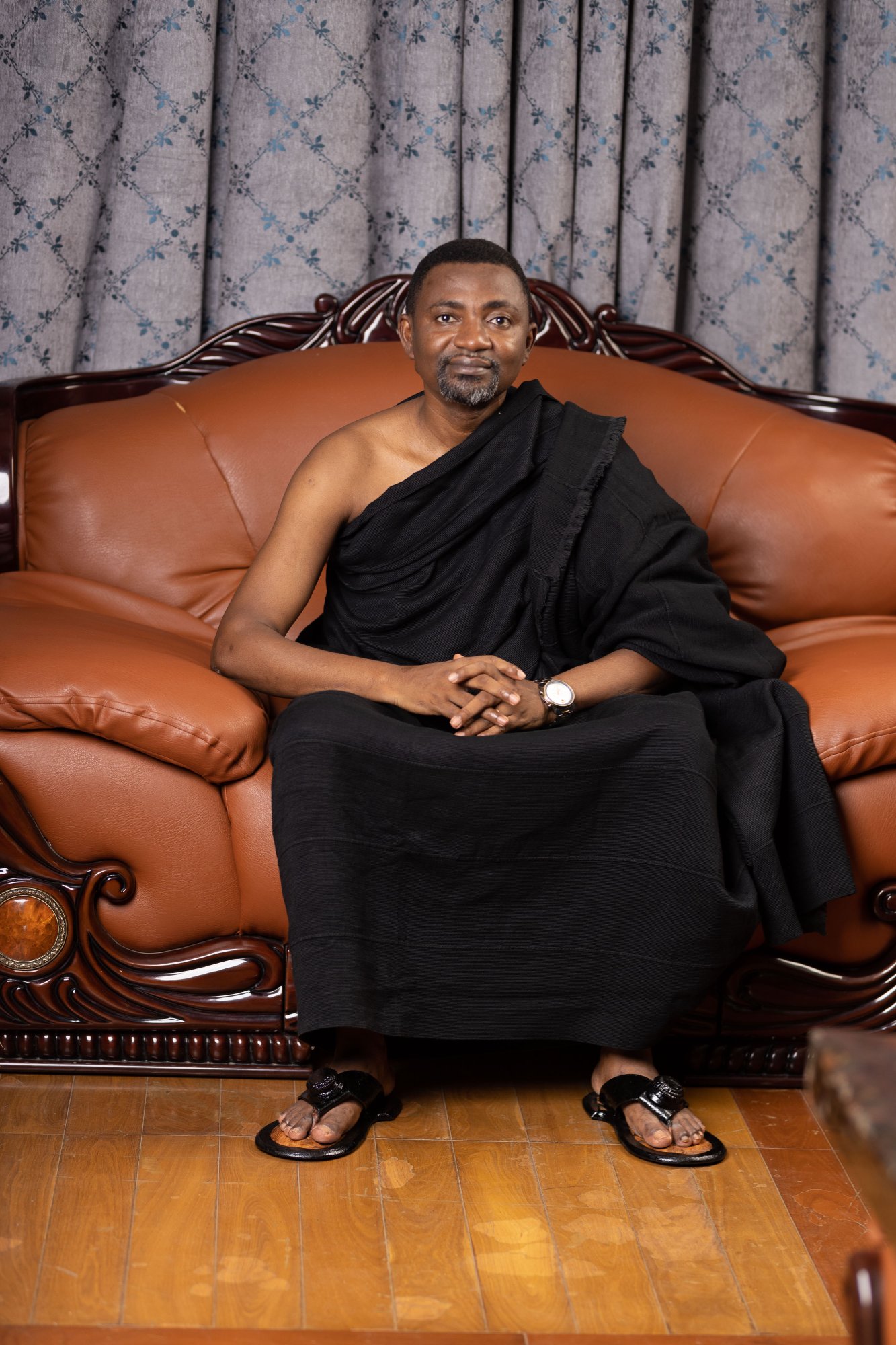Barima Acheampong Sarpong II seated in black ntoma